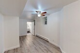 Located in Chicago's Edgewater neighborhood at 5726 N Winthrop Ave, this efficiently designed studio presents a clean, modern aesthetic throughout its single-floor layout. The open main area seamlessly integrates the living, dining, and kitchen functions, finished with light wood-tone laminate flooring, crisp white walls, and a ceiling fan with integrated lighting. A baseboard heating system and a window provide comfort and natural light to the living space. The kitchen is thoughtfully appointed with gray shaker-style cabinetry, a white subway tile backsplash, a stainless steel refrigerator, an electric range, and a single-basin sink — offering full cooking functionality in a compact footprint. Storage is well-addressed with a large double-door closet complemented by an adjacent built-in open shelving niche, keeping the space organized and clutter-free. The bathroom features neutral large-format tile flooring, a gray vanity with open lower shelving, a white countertop, a mirrored medicine cabinet, and strip vanity lighting, creating a clean and functional space. The consistent neutral palette and modern finishes throughout give this studio a cohesive, move-in-ready appeal suited for urban living.