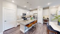 Located at 1980 Icon Way in Knoxville, Tennessee, this well-appointed 2-bedroom, 2-bathroom residence offers a thoughtfully designed single-floor layout with modern finishes throughout. The open-concept kitchen and living area serves as the heart of the home, showcasing crisp white shaker cabinetry, a subway tile backsplash, quartz countertops, and a large center island with seating for multiple guests. Stainless steel appliances, including a French door refrigerator, electric range, and built-in microwave, complete the kitchen. Wood-look plank flooring flows seamlessly throughout the entire residence, adding warmth and cohesion. The living room is bright and welcoming, with large windows that invite natural light and provide outdoor views, complemented by a ceiling fan overhead. Both bedrooms are generously sized, each featuring windows with natural light, ceiling fans, and dedicated closet space. The primary bedroom connects to an en-suite bathroom equipped with a glass-enclosed shower, white vanity cabinetry, quartz countertops, and an illuminated mirror. The second bathroom mirrors this refined aesthetic and features a tiled tub-shower combination. Two closets provide ample storage throughout the residence.