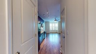 Located in Memphis, TN 38103, this studio is a well-designed, single-floor unit that makes efficient use of its compact footprint. The open-concept layout seamlessly connects the kitchen and living area, creating a cohesive and functional living space. Warm hardwood-style flooring runs throughout, lending a consistent and inviting aesthetic across every room.

The kitchen is outfitted with rich, dark-stained wood cabinetry offering ample storage, granite-look countertops, and a full suite of black appliances including an electric range, built-in microwave, refrigerator, and dishwasher. Track lighting overhead ensures the kitchen is well-lit and practical. The living area benefits from natural light filtering through a large window, complemented by a ceiling fan that adds both comfort and character.

A hallway connects the main living space to the full bathroom, which features a dark wood vanity with a granite-look countertop, a single-basin sink, a large mirror, and wood-style flooring that matches the rest of the unit. A notable convenience is the in-unit stacked washer and dryer, neatly tucked within the bathroom. The neutral, light-toned walls throughout the studio provide a clean, versatile backdrop well-suited for a variety of interior styles.