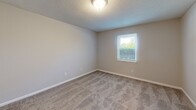 Located at 520 Michael St in Kernersville, NC, this 2-bedroom, 1-bathroom unit offers a practical and well-organized single-floor layout. The kitchen is equipped with gray cabinetry providing ample storage, white countertops, a double-basin sink, and black appliances including a range and refrigerator, all set atop warm hardwood-style flooring. The open floor plan, as seen in the dollhouse view, connects the kitchen to the living area, which also features hardwood-style flooring and benefits from natural light through a window. Both bedrooms are carpeted in a neutral tone and feature textured ceilings, soft wall colors, and windows that allow natural light to filter in. The primary bedroom is generously sized, offering comfortable living space, while the second bedroom is equally well-appointed with its own window and closet access. The bathroom is finished with hardwood-style flooring and includes a full tub-shower combo, vanity, and toilet in a clean, white finish. Throughout the unit, consistent neutral tones and clean lines create a cohesive, move-in-ready atmosphere suited for comfortable everyday living.