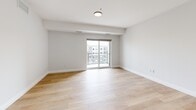 This contemporary 710 square foot apartment in Windsor, Ontario, showcases a thoughtful blend of functionality and style. The open-concept design seamlessly integrates the kitchen, living, and dining areas, creating a spacious feel. The kitchen is a highlight, boasting stainless steel appliances, ample cabinetry, and a large island with a sink, perfect for meal preparation and casual dining.

The bedroom, measuring 150 square feet, offers a private retreat with large windows allowing natural light to flood the space. A sliding glass door leads to a balcony, providing outdoor access and city views. The bathroom features modern fixtures, including a vanity with storage and a sleek shower.

Light wood flooring runs throughout the apartment, complementing the crisp white walls and creating a bright, airy ambiance. The unit includes in-unit laundry facilities, a convenience for modern living. Strategically placed windows throughout maximize natural light and offer panoramic views of the surrounding area.

The apartment's design emphasizes clean lines and a neutral color palette, allowing for personal touches in decor. With its efficient layout and contemporary amenities, this apartment presents an ideal living space for those seeking a modern urban lifestyle in Windsor.