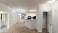 Located at 1201 Dulles Ave in Stafford, Texas, this single-floor residence offers a thoughtfully designed layout with a clean, neutral aesthetic throughout. The open-concept living and dining area is anchored by crown molding, plush carpeting, and an elegant chandelier that adds a touch of refinement. An entry closet provides convenient storage just steps from the front door.

The kitchen is efficiently arranged with white cabinetry, granite-style countertops, a tile backsplash, and black appliances including a refrigerator, electric range, microwave, and dishwasher. Wood-look luxury vinyl flooring runs throughout the kitchen, offering both durability and style.

The bedrooms are generously sized, each featuring plush carpeting and ceiling fans with lighting. One bedroom benefits from a large window that invites natural light and outdoor views, while another includes a built-in shelving nook and access to a private patio or exterior door, adding functional versatility.

The bathroom is outfitted with a wide granite-style vanity countertop, an extended mirror, wood-look flooring, and a full tub-shower combination. A dedicated closet adjacent to the bathroom provides additional storage.

Crown molding in the main living areas elevates the overall design, while the warm, neutral color palette creates a cohesive and welcoming atmosphere throughout the home.
