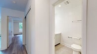This thoughtfully designed one-bedroom unit offers a comfortable and functional single-floor layout. The open-concept kitchen and living area serves as the heart of the space, where light wood-style flooring runs throughout, creating a cohesive and airy feel. The kitchen is outfitted with stainless steel appliances — including a refrigerator, electric range, and over-the-range microwave — complemented by white shaker-style cabinetry, subway tile backsplash, and a dark countertop that provides a modern contrast. The living room is bright and generously proportioned, featuring large sliding glass doors that open onto a private balcony, allowing natural light to pour in and offering pleasant views of surrounding greenery. The spacious primary bedroom includes a walk-in closet and a dedicated window that frames outdoor tree views, contributing to a calm and restful atmosphere. A well-appointed bathroom is finished with tile flooring, a white vanity, and clean white walls. A sliding-door closet is conveniently located in the hallway. Throughout the unit, a neutral white and light grey palette, combined with consistent flooring and modern fixtures, creates a clean, contemporary ambiance suited to a variety of lifestyles.