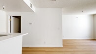 Located at 1765 N Sycamore Ave, Unit 319, in the heart of Hollywood, Los Angeles, this studio unit offers a well-organized, open-concept floor plan across a single level. Light hardwood flooring runs throughout the space, complementing the clean white walls and textured ceilings to create a bright, modern aesthetic.

The combined kitchen and living area forms the core of the unit. The kitchen features a peninsula-style breakfast bar with a white countertop, white cabinetry, and a full suite of stainless steel appliances including a refrigerator, gas range, and microwave. Under-cabinet lighting adds functionality to the workspace, while the open pass-through design keeps the kitchen connected to the living area.

The living area is open and versatile, benefiting from natural light through a sliding glass door that leads to a private balcony — ideal for outdoor relaxation with views of the surrounding neighborhood. An additional window further enhances natural light throughout the space.

The bathroom is clean and minimal, outfitted with a white vanity, toilet, and a grab bar, all finished consistently with the unit's modern palette. A dedicated closet provides essential storage. The overall ambiance is bright, functional, and contemporary, well-suited for urban living in one of Los Angeles's most vibrant neighborhoods.