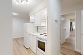 This well-appointed one-bedroom, one-bathroom unit in Chilliwack, BC offers a clean, modern aesthetic throughout its efficiently designed single-floor layout. Light wood laminate flooring flows seamlessly through every room, creating a bright and cohesive feel across the space.

The kitchen is compact yet functional, featuring white cabinetry with ample storage, a classic white subway tile backsplash, light marble-style countertops, and white appliances including a full-size refrigerator and electric range. Track lighting overhead ensures the kitchen is well-lit.

The living room is open and airy, with large sliding glass doors leading to a private balcony that brings in generous natural light and offers views of surrounding greenery and the neighbourhood. A baseboard heating system runs along the wall, providing efficient climate control.

The bedroom is a comfortable, well-proportioned room with the same light wood flooring, neutral walls, a window for natural light, and a built-in closet with shelving and hanging rods for organized storage.

The bathroom is neatly finished with a full soaking tub and shower, surrounded by large marble-patterned wall tiles in white and grey. A white vanity with storage and light wood flooring complete the clean, updated look of this room.