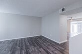 This two-floor residence offers a thoughtfully designed layout with consistent finishes throughout. The main level features dark hardwood-style flooring that flows through the open living areas. The living room is a standout space, anchored by a fireplace with a granite surround and flanked by windows fitted with white blinds that allow for ample natural light. A ceiling fan is visible in the adjoining area, which opens seamlessly to the rest of the main floor.

The kitchen is well-equipped with white shaker-style cabinetry, granite countertops, a classic subway tile backsplash, and stainless steel appliances including a dishwasher, range, and over-the-range microwave. A window above the sink provides additional natural light.

The bathrooms are finished with granite-topped white vanities, brushed nickel fixtures, and wood-style flooring. One bathroom features a full tub-shower combination, while another offers a more compact layout tucked beneath the staircase.

Upstairs, the bedrooms are carpeted in neutral tones and each feature windows with blinds, offering a quiet and comfortable retreat. Textured ceilings are present throughout the home, adding a consistent architectural detail across all levels. The overall palette of warm neutrals and updated finishes gives the space a clean, move-in-ready character.