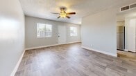 Located at 4235 N 35th Ave in Phoenix, Arizona, this single-story, one-bedroom, one-bathroom unit offers a thoughtfully designed layout that maximizes every square foot of its compact footprint. Light-toned wood-look flooring flows consistently throughout the space, creating a cohesive and modern aesthetic. Textured ceilings and ceiling fans are featured in each room, contributing to both comfort and visual character.

The open living area is bright and welcoming, with two windows flanking the front entry door that allow natural light to fill the space. The kitchen is positioned adjacent to the living area and features crisp white shaker-style cabinetry, light countertops, a stainless steel electric range, and a stainless steel refrigerator — a clean and functional setup for everyday cooking.

The bedroom offers a comfortable amount of space, complete with its own ceiling fan, a window for natural light, and built-in closet storage with bi-fold doors. The bathroom is straightforward and clean, featuring a combined tub and shower with white tile surround, chrome fixtures, and matching wood-look flooring that ties the space together. The overall ambiance of the unit is fresh, neutral, and move-in ready.