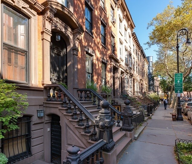 Elegant brownstones – complete with front stoops and iron railings – line the streets