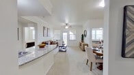 This single-floor residence is designed with an open, airy layout that seamlessly connects the main living spaces. The living room is generously sized, featuring plush carpeting, crown molding, a ceiling fan, and a glass-paneled door that floods the space with natural light. Adjacent to the living area, a dedicated dining space accommodates a full-sized table and benefits from the same bright, neutral palette and crown molding details.

The kitchen is well-equipped, featuring rich dark wood cabinetry, granite countertops, wood-look flooring, stainless steel appliances including a refrigerator and range, and a double sink along a peninsula that opens toward the dining and living areas, enhancing the open-concept flow.

The bedrooms are carpeted and comfortably proportioned, each with ceiling fans and windows providing natural light. A flexible additional room offers space suitable for a home office or den. Two full bathrooms feature wood-look plank flooring and dark vanity cabinetry with granite counters. One bathroom includes a walk-in shower, while the other offers a tub-shower combination. A dedicated laundry closet provides added convenience. Throughout, the consistent use of white walls and neutral finishes creates a clean, cohesive atmosphere.
