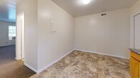 Located at 2002 Obear Ave in St. Louis, MO, this two-bedroom, two-bathroom unit offers a practical and well-organized single-floor layout. The kitchen is a functional centerpiece, featuring warm honey-toned wood cabinetry, granite-style countertops, tile flooring, and black appliances including a range and full-size refrigerator. A window above the sink allows natural light to brighten the space. The open living area is finished with neutral-toned carpet and crisp white walls, creating a clean and versatile backdrop. A connecting hallway provides smooth flow between the main living areas and the bedrooms. Both bedrooms are carpeted, with neutral walls and windows that bring in natural light; one bedroom includes a window-unit air conditioner. The two bathrooms are finished with tile flooring, and include a vanity with wood cabinetry. One bathroom features a full tub-shower combo with white tile surround and chrome fixtures. A dedicated laundry area with tile flooring and a wall-mounted access panel adds convenient in-unit utility. Throughout the unit, white panel doors, clean baseboards, and a consistent neutral palette contribute to a tidy, move-in-ready atmosphere.