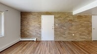 Located at 529 E Main St in Ravenna, Ohio, this single-floor home offers three bedrooms and one bathroom within a practical and well-organized layout. The living room makes a strong first impression with a full exposed brick accent wall, wood-style flooring, and a large window that fills the space with natural light. The kitchen connects directly to the living area and features rich, dark wood cabinetry extending from floor to ceiling, light-toned countertops, a single-basin sink, and a dishwasher — providing ample storage and workspace for everyday use. Each of the three bedrooms is finished with light hardwood-style flooring and crisp white walls, creating a clean and neutral aesthetic. The primary bedroom is generously sized and includes a wide bifold closet, while additional bedrooms offer windows overlooking the surrounding greenery and neighborhood. A dedicated closet provides extra storage. The full bathroom includes a tub-shower combination, toilet, and vanity with wood cabinetry, finished with wood-style flooring and a textured ceiling. Baseboard heating is present throughout the home, and a wall-unit air conditioner is featured in the living room. The overall design is straightforward and functional, making this an accessible and practical home.