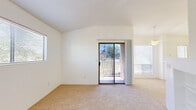 Located at 201 S Camino Seco in Tucson, Arizona, this single-story, one-bedroom, one-bathroom residence offers a well-organized layout with a bright and airy feel throughout. The combined living and dining area is a standout space, highlighted by vaulted ceilings, soft carpeting, and generous natural light from multiple windows and a sliding glass door that opens to an outdoor view. A tile-surround wood-burning fireplace serves as the focal point of the living area, flanked by built-in shelving for added functionality and character. The kitchen is efficiently designed with wood-accented cabinetry, white countertops, a double sink, and a full suite of appliances including a stove, microwave, and refrigerator. A peninsula counter with a pendant light overhead provides a natural transition to the dining space. The bedroom is a comfortable, carpeted retreat with a window that brings in natural light and connects via a hallway to the rest of the home. The bathroom features wood-look vinyl flooring, a vanity with countertop storage, and a full tub-shower combination. Clean white walls and consistent finishes throughout create a cohesive, move-in ready environment well-suited for Tucson living.