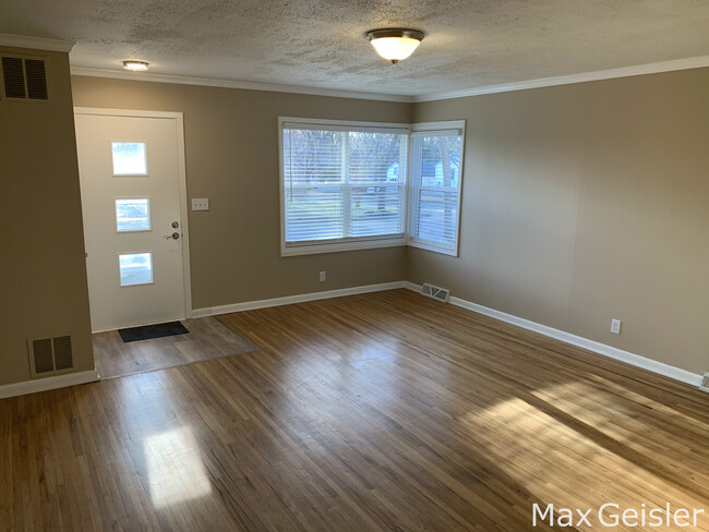 Large windows and hardwood floors in living room. - 404 12th Ave N
