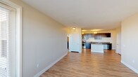 Located at 1600 Coalton Rd in Broomfield, Colorado, this single-floor residence offers a clean, contemporary design with a well-planned open-concept layout. The living and dining areas are finished with smooth light-toned hardwood-style flooring that flows seamlessly throughout the main living spaces, creating a bright and cohesive atmosphere. Large windows invite generous natural light and offer pleasant outdoor views, enhancing the overall sense of openness.

The kitchen is a standout feature, appointed with rich dark espresso cabinetry, stainless steel appliances including a refrigerator, range, microwave, and dishwasher, and neutral stone-toned countertops. A central island provides additional prep and seating space, making the kitchen as functional as it is visually appealing. Pendant lighting adds a polished finishing touch.

The bedrooms are carpeted for comfort and each include ceiling fans and ample natural light through generously sized windows with blinds. The floor plan also reveals well-proportioned rooms that offer flexibility for various uses.

The bathrooms are finished with classic white subway tile, featuring both a tiled soaking tub with a curved shower rod and a separate walk-in glass-door shower. Warm-toned walls and hardwood-style flooring carry through these spaces for a consistent design aesthetic throughout the home.