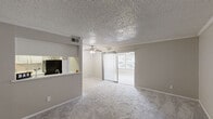Located at 9750 Forest Ln in Dallas, TX, this single-floor residence offers three bedrooms and two full bathrooms within a efficiently designed layout. The open-concept living room features plush carpeting, a ceiling fan with light fixture, a textured ceiling, and sliding glass doors that invite natural light and provide access to an outdoor area. A pass-through counter connects the living space to the galley-style kitchen, which is outfitted with white cabinetry, a stainless steel sink, wood-look vinyl flooring, and black appliances including a refrigerator and range. The bathrooms are clean and functional, each featuring a tub-shower combo, white vanity with an integrated sink, and wood-look flooring. The bedrooms are carpeted and feature textured ceilings, with some rooms showcasing ceiling fans, crown molding accents, and windows that bring in natural light. One bedroom includes a spacious walk-in closet with dual shelving rods and built-in shelving, offering generous storage. The primary bedroom provides a comfortable and well-sized retreat. Throughout the home, a neutral color palette and consistent finishes create a cohesive and practical living environment.