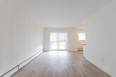 Located at 321 Marland Ave in Oshawa, Ontario, this 2-bedroom, 1-bathroom unit offers a thoughtfully arranged single-floor layout with a bright, neutral aesthetic throughout. Light wood-tone flooring runs continuously across the space, complementing the clean white walls and creating a cohesive, airy feel.

The galley-style kitchen is well-equipped with white shaker cabinetry, dark countertops, a classic subway tile backsplash, and a full suite of stainless steel appliances including a refrigerator, electric range, and built-in microwave. A double stainless steel sink with a window above adds functionality and natural light.

The combined kitchen and living area opens to a sliding glass door, allowing abundant natural light and providing outdoor views. The living space is open and versatile, finished with baseboard heating and roller shades on the windows.

Both bedrooms are comfortably proportioned, featuring the same warm wood-tone flooring, neutral walls, and individual windows. The primary bedroom includes a mirrored sliding-door closet, adding a sense of depth and storage convenience.

The bathroom is finished with white subway tile surrounding a soaker tub and shower, a window for natural light and ventilation, a white vanity, and chrome fixtures — offering a clean and timeless look throughout.