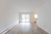 Located at 321 Marland Ave in Oshawa, Ontario, this 2-bedroom, 1-bathroom unit offers a thoughtfully arranged single-floor layout with a bright, neutral aesthetic throughout. Light wood-tone flooring runs continuously across the space, complementing the clean white walls and creating a cohesive, airy feel.

The galley-style kitchen is well-equipped with white shaker cabinetry, dark countertops, a classic subway tile backsplash, and a full suite of stainless steel appliances including a refrigerator, electric range, and built-in microwave. A double stainless steel sink with a window above adds functionality and natural light.

The combined kitchen and living area opens to a sliding glass door, allowing abundant natural light and providing outdoor views. The living space is open and versatile, finished with baseboard heating and roller shades on the windows.

Both bedrooms are comfortably proportioned, featuring the same warm wood-tone flooring, neutral walls, and individual windows. The primary bedroom includes a mirrored sliding-door closet, adding a sense of depth and storage convenience.

The bathroom is finished with white subway tile surrounding a soaker tub and shower, a window for natural light and ventilation, a white vanity, and chrome fixtures — offering a clean and timeless look throughout.