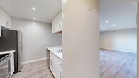 Located at 3135 Campus Dr in San Mateo, CA, this one-bedroom, one-bathroom residence offers a clean, modern aesthetic throughout its efficiently designed single-floor layout. Light-toned luxury vinyl plank flooring runs through the main living areas, complementing the neutral gray palette that gives the space a bright, cohesive feel.

The kitchen is a standout feature, boasting white shaker cabinetry with brushed nickel hardware, white quartz countertops, a stainless steel sink, and a full suite of stainless steel appliances including a refrigerator, range, and dishwasher. The galley-style layout flows seamlessly into the combined dining and living area, which is anchored by recessed lighting and large sliding glass doors that open onto a private balcony overlooking lush greenery.

The spacious primary bedroom features plush wall-to-wall carpeting, crown molding, and a generous window with views of surrounding foliage, filling the room with natural light. Three closets provide ample storage throughout the unit.

The bathroom is elegantly finished with large-format tile surrounding a tub-shower combo enclosed by a sliding glass door, mosaic accent tile detailing, wood-look flooring, and a white vanity with a marble-style countertop. A hallway connects all areas of the home, completing this well-organized and stylish residence.