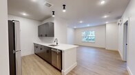 This thoughtfully designed one-bedroom, one-bathroom unit in Newington, CT, offers a modern living experience with clean lines and contemporary finishes throughout. Light wood-tone flooring flows seamlessly across every room, creating a warm, cohesive aesthetic.

The open-concept kitchen is a standout feature, equipped with dark wood cabinetry accented by matte black hardware, white quartz countertops, a subway tile backsplash, and a full suite of stainless steel appliances including a refrigerator, range, microwave, and dishwasher. A peninsula with an undermount sink and additional seating space opens directly into the living room, which is bathed in natural light from a large window and outfitted with recessed lighting and a wall-mounted mini-split system for efficient climate control.

The bedroom is a comfortable, well-proportioned retreat featuring a double closet with paneled doors, a dedicated window for natural light, and its own wall-mounted mini-split unit. The full bathroom continues the modern theme with a dark wood vanity, white quartz countertop, a framed mirror, and a shower-tub combination. A connecting hallway provides practical circulation throughout the unit. The overall ambiance is bright, clean, and move-in ready.