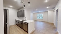 This thoughtfully designed one-bedroom, one-bathroom unit in Newington, CT, offers a modern living experience with clean lines and contemporary finishes throughout. Light wood-tone flooring flows seamlessly across every room, creating a warm, cohesive aesthetic.

The open-concept kitchen is a standout feature, equipped with dark wood cabinetry accented by matte black hardware, white quartz countertops, a subway tile backsplash, and a full suite of stainless steel appliances including a refrigerator, range, microwave, and dishwasher. A peninsula with an undermount sink and additional seating space opens directly into the living room, which is bathed in natural light from a large window and outfitted with recessed lighting and a wall-mounted mini-split system for efficient climate control.

The bedroom is a comfortable, well-proportioned retreat featuring a double closet with paneled doors, a dedicated window for natural light, and its own wall-mounted mini-split unit. The full bathroom continues the modern theme with a dark wood vanity, white quartz countertop, a framed mirror, and a shower-tub combination. A connecting hallway provides practical circulation throughout the unit. The overall ambiance is bright, clean, and move-in ready.
