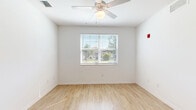 Located at 2115 Lepic Ln in Kissimmee, FL, this single-floor, 2-bedroom, 2-bathroom residence offers a well-organized and functional layout. The kitchen is a standout feature, appointed with rich dark wood cabinetry, light countertops, recessed lighting, and black appliances including a refrigerator, range, and dishwasher. Warm light wood-style flooring runs throughout the main living and kitchen areas, creating a bright, cohesive feel.

A connecting hallway links the living spaces to the two bedrooms, each finished with plush carpeting, ceiling fans, and windows that invite natural light and views of the surrounding greenery. The primary bedroom includes a spacious walk-in closet outfitted with wire shelving systems, providing generous storage capacity. The second bedroom is served by its own closet as well.

Both bathrooms mirror each other in clean, functional design, featuring a tub-shower combination, single-sink vanity, and light wood-style tile flooring. One bathroom features a darker wood vanity, while the other offers a crisp white finish — both maintaining a bright, tidy aesthetic. The overall design of this residence prioritizes practicality and comfort with a neutral palette throughout.