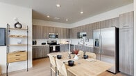 This thoughtfully designed 2-bedroom, 1-bathroom residence offers a seamless blend of modern aesthetics and functional living. The open-concept kitchen and living area serves as the heart of the home, featuring a well-equipped kitchen with wood-toned cabinetry extending to the ceiling, stainless steel appliances including a French door refrigerator, electric range, microwave, and dishwasher, all complemented by clean white countertops and light hardwood-style flooring. A dedicated dining area with a natural wood table anchors the space comfortably. The adjacent living room is bright and airy, with multiple large windows that invite generous natural light and are dressed with sheer white curtains. The spacious primary bedroom is a standout feature, offering plush carpeting, recessed lighting, and a sliding glass door that opens to a private balcony with open landscape views. The second bedroom provides a similarly calm and comfortable retreat. A pantry offers additional storage, while the full bathroom is finished with matching wood-toned cabinetry, a white countertop vanity, and a tub-shower combination. The entrance and staircase complete this well-organized and cohesive floor plan, making it an informative and inviting space throughout.