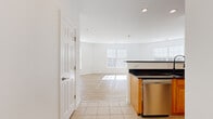 This single-floor residence offers a thoughtfully designed layout that balances comfort and functionality. The open-concept living and dining area is bathed in natural light streaming through multiple large windows fitted with white blinds, highlighting the smooth light hardwood flooring that extends throughout the main living space. Recessed lighting adds a polished touch to the bright, white-walled interior.

The kitchen is a standout feature, showcasing warm honey-toned oak cabinetry with ample upper and lower storage, sleek dark granite countertops, and a full suite of stainless steel appliances including a gas range, built-in microwave, refrigerator, and dishwasher. Tile flooring grounds the kitchen with a clean, durable finish.

The bedrooms offer a cozy atmosphere with plush carpeting, generous closet space, and an abundance of natural light. The bathrooms maintain a crisp, clean aesthetic with white tile, a soaking tub with shower combination, and brushed gold fixtures.

Overall, the space presents a bright, neutral palette throughout, creating a versatile and welcoming environment that is move-in ready.