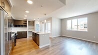 Located at 1774 Metro Avenue in Chula Vista's San Diego County, this modern 2-bedroom, 2-bathroom apartment offers 970 square feet of thoughtfully designed single-floor living. The contemporary kitchen is a standout feature, equipped with dark wood-toned cabinetry, stainless steel appliances including a refrigerator, range, and microwave, a white quartz waterfall island with an integrated sink, a classic tile backsplash, and warm wood-style flooring. The open layout connects the kitchen seamlessly to the living area. The primary bedroom spans 160 square feet with light wood-style flooring, neutral walls, and a large window providing urban views of the surrounding community. It is complemented by a walk-in closet outfitted with dual hanging rods and built-in shelving. The primary bathroom features a dark wood vanity with quartz countertop, a large mirror, and a soaking tub. The secondary bedroom is carpeted with a large window offering neighborhood views. The second bathroom includes a glass-enclosed walk-in shower and wood-style flooring. Throughout the unit, neutral tones and clean finishes contribute to a bright, modern ambiance.