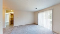 Located at 4412 Ridgeway Cir in Kalamazoo, MI, this one-bedroom, one-bathroom unit offers a practical and well-organized single-floor layout. The combined living and dining area is carpeted and filled with natural light, courtesy of large sliding glass doors fitted with vertical blinds that open the space to outdoor views. The open-concept kitchen is positioned along a peninsula counter with a clean white surface and a stainless steel sink, offering a functional pass-through design. Warm oak cabinetry lines the upper walls and extends to the ceiling, providing generous storage, while white appliances — including a range, microwave, and refrigerator — complete the setup. Light wood-style flooring runs through the kitchen area, contrasting with the plush carpet found in the living and sleeping spaces. The bedroom is notably spacious, featuring two wide windows on adjacent walls that bring in ample natural light and treetop views, creating a bright and airy atmosphere. Four closets throughout the unit offer exceptional storage capacity. The bathroom includes a wood-toned vanity with a white countertop, a full tub/shower combination with grab bars, and light wood-style tile flooring, maintaining a clean and neutral aesthetic throughout.