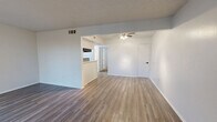 Located along E R L Thornton Freeway in Dallas, TX, this single-story, one-bedroom, one-bathroom unit offers a practical and clean layout across a comfortable floor plan. The combined kitchen and living area forms the heart of the unit, featuring wood-look plank flooring, neutral white walls, and a window that allows natural light to fill the space. The kitchen is efficiently designed in a galley style, equipped with a gas range, dishwasher, white cabinetry with black hardware, light quartz-style countertops, and a distinctive mosaic tile backsplash in a black-and-white pattern that adds visual interest. The open living area provides a versatile space suitable for various furniture arrangements. The bedroom is generously sized, finished with plush carpet, a ceiling fan with light fixture, a textured ceiling, and an arched window that brings in natural light. A dedicated closet offers convenient storage directly off the bedroom. The full bathroom is clean and functional, featuring wood-look flooring, a single-sink vanity with light countertops and black hardware, a tiled tub-and-shower combination, and a large mirror. A separate closet adds additional storage to the overall unit.