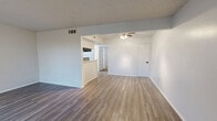 Located along E R L Thornton Freeway in Dallas, TX, this single-story, one-bedroom, one-bathroom unit offers a practical and clean layout across a comfortable floor plan. The combined kitchen and living area forms the heart of the unit, featuring wood-look plank flooring, neutral white walls, and a window that allows natural light to fill the space. The kitchen is efficiently designed in a galley style, equipped with a gas range, dishwasher, white cabinetry with black hardware, light quartz-style countertops, and a distinctive mosaic tile backsplash in a black-and-white pattern that adds visual interest. The open living area provides a versatile space suitable for various furniture arrangements. The bedroom is generously sized, finished with plush carpet, a ceiling fan with light fixture, a textured ceiling, and an arched window that brings in natural light. A dedicated closet offers convenient storage directly off the bedroom. The full bathroom is clean and functional, featuring wood-look flooring, a single-sink vanity with light countertops and black hardware, a tiled tub-and-shower combination, and a large mirror. A separate closet adds additional storage to the overall unit.