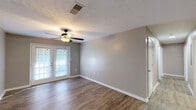 Located at 60 Heery Rd in Newnan, Georgia, this single-floor, 2-bedroom, 1-bathroom home offers a practical and comfortable layout with consistent wood-look flooring and neutral tones throughout. The combined kitchen and living area serves as the heart of the home. The living room features French doors that bring in natural light and open to a private wooden deck overlooking a lush, wooded backdrop — a serene outdoor retreat. A ceiling fan adds comfort to the space. The kitchen is well-equipped with warm oak cabinetry, dark countertops, a double sink, and white appliances including a range, microwave, and refrigerator, complemented by a stainless steel dishwasher. A hallway connects the living areas to the two bedrooms, each outfitted with a ceiling fan and closet access. The primary bedroom includes a walk-in closet with wire shelving and a dedicated laundry connection, adding everyday convenience. The shared full bathroom features a full-size soaking tub and shower combination with chrome fixtures. Textured ceilings and clean white trim are consistent throughout, lending the home a tidy, cohesive feel. The property also benefits from its proximity to the natural surroundings of Newnan, GA.