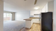 Located at 1825 Poggi St in Alameda, California, this one-bedroom, one-bathroom residence offers a thoughtfully designed single-level layout. The open-concept kitchen and living area form the heart of the home, where wood-look flooring flows through the kitchen and transitions to plush carpet in the living room. The kitchen is well-appointed with crisp white shaker cabinetry, rich granite countertops, a peninsula breakfast bar, a stainless steel gas range, and a stainless steel refrigerator — providing both style and functionality. The living room is generously proportioned and features a ceiling fan and a sliding glass door that opens directly onto a private balcony with a wooden railing, allowing for natural light and outdoor views. The bedroom offers comfortable carpeted flooring, a bright window with blinds, and a full-width mirrored sliding closet that enhances the sense of space. A wall heater unit provides efficient climate control. The bathroom is clean and practical, featuring wood-look flooring, a granite-topped vanity, and a full tub-shower combination with white tile surround. Throughout the residence, neutral tones and clean finishes create a calm, move-in-ready atmosphere.