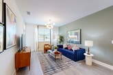 Located at 100 Oakbrook Drive in McDonough, GA, this single-floor, 2-bedroom, 2-bathroom residence offers a thoughtfully designed layout with modern finishes and a bright, welcoming ambiance. The open-concept living, dining, and kitchen area forms the heart of the home, where light wood-look flooring flows seamlessly throughout. The kitchen is equipped with stainless steel appliances—including a side-by-side refrigerator with ice maker and a built-in microwave—crisp white cabinetry, clean countertops, a dedicated pantry, and a central island with bar seating, ideal for casual dining and entertaining. The living room is bathed in natural light from large windows and features a modern globe chandelier, creating an inviting and stylish atmosphere. The primary bedroom offers a peaceful retreat with a vibrant accent wall, generous natural light, direct access to its private en-suite bathroom, and a spacious walk-in closet with wire shelving. Both bathrooms are finished with white vanities, white countertops, and large mirrors. One bathroom features distinctive black-and-white checkered tile flooring for a bold design touch. Additional conveniences include a dedicated laundry room, a utility room, and three closets, ensuring ample storage throughout the residence.