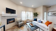 Located at 61560 Aaron Way in Bend, Oregon, this well-appointed 1-bedroom, 2-bathroom home offers an efficient and thoughtfully designed single-floor layout. The living room serves as the heart of the space, featuring a tiled fireplace with a clean white mantle, recessed lighting, warm wood-look flooring, and large windows dressed with sheer curtains that invite abundant natural light and views of the surrounding neighborhood. The kitchen is equipped with stainless steel appliances, gray shaker-style cabinetry, granite-style countertops, and a breakfast bar with seating — ideal for casual dining. A sliding barn door leads to an in-unit laundry area, adding everyday convenience. The bedroom offers plush carpet, a vaulted ceiling accent, and a private door with direct outdoor access to a patio. Two full bathrooms serve the home, including one en-suite bathroom off the bedroom featuring tile flooring, a walk-in shower with glass enclosure, and a vanity with granite countertops. A dedicated closet provides organized storage. Neutral tones and modern finishes throughout create a clean, cohesive aesthetic well-suited to comfortable living in Central Oregon.
