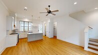 Located at 115 Gaunt Ln in Youngsville, Louisiana, this two-story home offers 2 bedrooms and 4 bathrooms across two well-proportioned floors. The main level hosts the kitchen and living area, while the upper level contains the primary bedroom suite and additional accommodations.

The kitchen is a standout feature, showcasing white shaker cabinetry with gold hardware, a marble-veined quartz island, stainless steel appliances including a gas range and dishwasher, and a grid-paned window above the sink that fills the space with natural light. A pendant light adds a refined touch overhead, while light hardwood flooring runs throughout the main living areas.

The bedrooms are bright and airy, with large grid-style windows, ceiling fans, and clean white walls. The primary bedroom is generously sized and benefits from an abundance of natural light. The four bathrooms are finished in crisp white tones with marble-look surfaces and dark bronze hardware accents, maintaining a consistent and polished aesthetic.

Additional features include a dedicated laundry room and a spacious covered carport with open views of the surrounding community. The exterior siding and concrete driveway lend a clean, low-maintenance finish. Overall, the home presents a cohesive, modern aesthetic with quality finishes throughout.