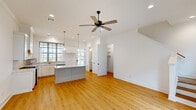 Located at 115 Gaunt Ln in Youngsville, Louisiana, this two-story home offers 2 bedrooms and 4 bathrooms across two well-proportioned floors. The main level hosts the kitchen and living area, while the upper level contains the primary bedroom suite and additional accommodations.

The kitchen is a standout feature, showcasing white shaker cabinetry with gold hardware, a marble-veined quartz island, stainless steel appliances including a gas range and dishwasher, and a grid-paned window above the sink that fills the space with natural light. A pendant light adds a refined touch overhead, while light hardwood flooring runs throughout the main living areas.

The bedrooms are bright and airy, with large grid-style windows, ceiling fans, and clean white walls. The primary bedroom is generously sized and benefits from an abundance of natural light. The four bathrooms are finished in crisp white tones with marble-look surfaces and dark bronze hardware accents, maintaining a consistent and polished aesthetic.

Additional features include a dedicated laundry room and a spacious covered carport with open views of the surrounding community. The exterior siding and concrete driveway lend a clean, low-maintenance finish. Overall, the home presents a cohesive, modern aesthetic with quality finishes throughout.