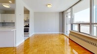 Located at 100 Parkway Forest Dr in Toronto's Parkway Forest neighbourhood, this well-appointed 3-bedroom, 2-bathroom unit offers a functional and comfortable layout across a single floor. The open-concept kitchen and living area form the heart of the home, where gleaming parquet wood flooring extends throughout, reflecting abundant natural light. The kitchen is outfitted with white shaker-style cabinetry, a subway tile backsplash, stainless steel appliances including a dishwasher and range, and a peninsula that provides additional counter space and separates the kitchen from the living area. Floor-to-ceiling windows in the living room frame sweeping city skyline views and flood the space with natural light. The spacious primary bedroom features large windows overlooking the cityscape, parquet flooring, and baseboard heating. The additional bedrooms are well-sized, each with parquet flooring and generous closet storage, including a double-door closet in one room. The two bathrooms are finished in clean white tile, with one featuring a full soaker tub and tiled surround, and the other offering a vanity with ample counter space. A dedicated hallway and closet round out this bright, practical unit.