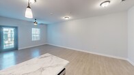 This contemporary 810-square-foot apartment in Chattanooga, TN, offers a perfect blend of style and functionality. The open-concept design maximizes space, creating a seamless flow between the living areas. The gourmet kitchen is a highlight, boasting dark wood cabinetry, stainless steel appliances, and a stunning marble-look countertop with a spacious island. Pendant lighting adds a touch of elegance.

The living area is bright and airy, with large windows allowing natural light to flood the space. Light wood-look flooring runs throughout, complementing the neutral wall colors. A modern ceiling fan provides both style and comfort.

The bedroom, measuring 160 square feet, offers ample space and features a large closet with sliding doors. The bathroom is designed with accessibility in mind, featuring a walk-in shower with a built-in seat and support bars.

Additional amenities include in-unit laundry facilities and plenty of storage space. The apartment's layout, as seen in the 3D floor plan, showcases the efficient use of space, making this compact home feel much larger than its square footage suggests.