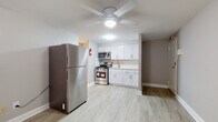 This single-floor unit offers a practical and well-appointed layout designed for comfortable everyday living. The kitchen is a standout feature, outfitted with a full suite of stainless steel appliances including a gas range, over-the-range microwave, and a full-size refrigerator. Clean white shaker-style cabinetry lines the walls, complemented by light countertops and a single-basin sink. Light wood-look luxury vinyl plank flooring runs throughout the main living and kitchen areas, lending a bright and cohesive feel to the space.

The open living area flows naturally from the kitchen, with a ceiling fan providing both light and air circulation. A wall-mounted air conditioning unit and baseboard heating ensure year-round climate comfort. The bedroom is carpeted for warmth and features a window fitted with blinds, allowing for natural light while maintaining privacy. Baseboard heating extends into this room as well, ensuring consistent comfort throughout the colder months.

The bathroom is finished simply and cleanly, featuring a full-size soaking tub with a tiled surround and a toilet, keeping the space functional and easy to maintain. Overall, this unit presents a tidy, move-in-ready space with updated finishes throughout.