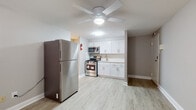 This single-floor unit offers a practical and well-appointed layout designed for comfortable everyday living. The kitchen is a standout feature, outfitted with a full suite of stainless steel appliances including a gas range, over-the-range microwave, and a full-size refrigerator. Clean white shaker-style cabinetry lines the walls, complemented by light countertops and a single-basin sink. Light wood-look luxury vinyl plank flooring runs throughout the main living and kitchen areas, lending a bright and cohesive feel to the space.

The open living area flows naturally from the kitchen, with a ceiling fan providing both light and air circulation. A wall-mounted air conditioning unit and baseboard heating ensure year-round climate comfort. The bedroom is carpeted for warmth and features a window fitted with blinds, allowing for natural light while maintaining privacy. Baseboard heating extends into this room as well, ensuring consistent comfort throughout the colder months.

The bathroom is finished simply and cleanly, featuring a full-size soaking tub with a tiled surround and a toilet, keeping the space functional and easy to maintain. Overall, this unit presents a tidy, move-in-ready space with updated finishes throughout.