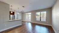 Located in Sugar Land, TX, this thoughtfully designed one-bedroom, one-bathroom residence offers a well-organized single-level layout encompassing a comfortable range of living spaces. The open-concept living and dining area is a standout feature, showcasing rich, dark hardwood-style flooring, neutral gray walls, and abundant natural light streaming through large windows and French doors that provide pleasant outdoor views. The kitchen is designed in a galley style, featuring dark espresso cabinetry, granite countertops, a stainless steel refrigerator, and light wood-tone flooring — efficiently connected to the main living area via a peninsula counter. A dedicated office provides a functional workspace separate from the primary bedroom, which is generously proportioned and includes a ceiling fan and access to a spacious walk-in closet with built-in shelving and hanging rods. The full bathroom is well-appointed with dark wood vanity cabinetry, granite countertops, a large mirror, and a shower/tub combination. Additional highlights include a convenient in-unit laundry area, multiple closets for ample storage, and a welcoming entrance. The overall ambiance is clean, modern, and move-in ready.