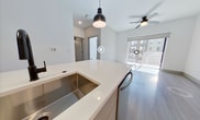 Step into a world of contemporary elegance and effortless living. This exquisite 560 sq ft apartment at Aura 245 is a testament to modern design and smart urban living. The moment you enter, you're greeted by an abundance of natural light streaming through floor-to-ceiling sliding doors, creating an airy and inviting atmosphere.

The heart of this home is the open-concept living area, where sleek lines and a neutral color palette provide the perfect canvas for your personal style. The living room seamlessly flows into a private balcony, offering a tranquil outdoor retreat and expanding your living space.

The kitchen is a culinary enthusiast's dream, boasting high-end stainless steel appliances, including a spacious side-by-side refrigerator. Crisp white cabinetry, contrasted by dark hardware, adds a touch of sophistication, while the subway tile backsplash and under-cabinet lighting elevate the space. The central island with a built-in sink is perfect for casual dining or entertaining.

The generously sized 130 sq ft bedroom is a serene sanctuary, featuring plush carpeting and ample natural light. The bathroom is a spa-like retreat with a glass-enclosed shower, modern vanity, and sleek fixtures.

Throughout the apartment, you'll find thoughtful details like a modern ceiling fan, stylish light fixtures, and durable wood-look flooring. With its perfect blend of style, comfort, and convenience, this apartment isn't just a place to live – it's a lifestyle upgrade. Welcome home to your urban sanctuary.