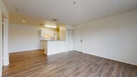 Located at 2562 Tenth St in Sarasota, Florida, this single-floor unit offers a functional and well-organized layout designed for comfortable everyday living. The open-concept living and dining area features warm wood-look vinyl flooring, a textured ceiling, and generous natural light streaming in through large windows and sliding glass doors that lead to a private balcony with outdoor views of the surrounding neighborhood.

The kitchen is positioned on a peninsula layout, offering granite-style countertops, white cabinetry, an electric range, refrigerator, and an under-cabinet range hood. The peninsula provides a natural division between the kitchen and living spaces while maintaining an open feel throughout.

The bedroom is carpeted for comfort and includes a ceiling fan with integrated lighting and a window fitted with blinds, allowing for natural light and ventilation. A louvered closet door adds a classic touch to the space.

The bathroom is equipped with a full tub and shower combination, a vanity with matching granite-style countertops, white cabinetry, and wood-look vinyl flooring. A stacked washer and dryer unit is conveniently located within the bathroom, adding practical in-unit laundry access. The overall aesthetic is clean and neutral, making the space move-in ready and easy to personalize.