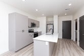 Located at 800 E 620 S in American Fork, Utah, this thoughtfully designed 2-bedroom, 1-bathroom residence offers a clean, contemporary aesthetic across a single floor. The open-concept kitchen serves as the heart of the home, showcasing warm wood-tone cabinetry, white quartz countertops, a central island with an undermount sink and matte black faucet, and a full suite of stainless steel appliances including an electric range and built-in microwave. Light hardwood-style flooring runs throughout the main living area, amplifying the bright, airy feel enhanced by recessed lighting and a large sliding glass door that invites natural light. The two bedrooms are carpeted for comfort, with the primary bedroom offering a generous footprint, recessed lighting, and direct access to the shared bathroom. The second bedroom benefits from dual windows with horizontal blinds, filling the space with abundant natural light. The full bathroom features a wood-toned vanity with a white quartz countertop, a tub-shower combo, wood-look tile flooring, and ample storage. Clean white walls and modern finishes throughout lend the unit a fresh, move-in-ready appeal well suited to everyday living.