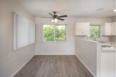 Located at 530 W First St in Tustin, California, this 2-bedroom, 1-bathroom single-floor unit offers a practical and comfortable layout designed to maximize its well-proportioned footprint. The open-concept living, dining, and kitchen area forms the heart of the home, where light wood-style flooring flows seamlessly into the kitchen and transitions to plush carpeting in the living space. A ceiling fan with lighting overhead adds both style and function to this combined area.

The kitchen is well-equipped with ample white cabinetry, generous counter space featuring speckled laminate countertops, a double-basin stainless steel sink, and a gas range. A peninsula divides the kitchen from the dining and living areas, and a window above the sink brings in natural greenery views. Vertical blinds throughout the unit allow for flexible light control.

Both bedrooms are carpeted and feature ceiling fans, closets, and windows with outdoor views, lending each room a bright and airy feel. The primary bedroom offers a comfortable and private retreat. Three closets throughout the unit provide practical storage solutions.

The bathroom includes a full tub-shower combo with white tile surround, a pedestal sink, and a small operable window for ventilation. A hallway connects the living areas to the bedrooms and bath, keeping the layout organized and efficient.