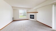 Located at 3533 Willow Ave in White Bear Lake, Minnesota, this single-floor, 2-bedroom, 2-bathroom home offers a well-organized and comfortable layout. The living room serves as the focal point of the home, featuring plush carpeting, a corner fireplace with a wood mantel and built-in shelving, and a large window that fills the space with natural light and outdoor views. Warm wood trim and neutral tones carry throughout, creating a cohesive and inviting atmosphere.

The kitchen is equipped with rich oak cabinetry offering generous storage, light countertops, a double-basin sink, and white appliances including a dishwasher and range, complemented by a stainless steel refrigerator. Hardwood-style flooring runs through the kitchen and dining area, which opens conveniently toward the living room.

Both bedrooms are carpeted and feature closets with wood-tone doors and windows providing natural light. The primary bedroom is spacious, offering ample room for furnishings. The bathrooms include warm wood vanities with white countertops; one bathroom features a walk-in shower with grab bars and hardwood-style flooring.

A dedicated in-unit laundry room houses a full-size washer and dryer with overhead shelving, adding everyday convenience. Textured ceilings and consistent wood trim details complete the home's classic, functional design.