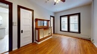Located at 102 E 19th St in Minneapolis, MN, this one-bedroom, one-bathroom unit offers a functional and straightforward layout across a single floor. Warm hardwood flooring flows throughout the living room, bedroom, and entryway areas, lending a classic character to the space. The living room features a ceiling fan, a large window that invites natural light, and dark wood trim detailing around the doors and windows, adding a traditional architectural touch.

The galley-style kitchen is efficiently designed with white cabinetry, a gas range, a full-size refrigerator, a double-basin sink, and tile countertops. A window above the sink provides natural light and ventilation. White subway tile backsplash completes the clean aesthetic.

The bedroom is a well-proportioned room with continued hardwood flooring and direct access to a dedicated closet with built-in shelving. A second closet elsewhere in the unit provides additional storage flexibility.

The bathroom includes a pedestal sink, a full bathtub with a tiled shower surround, and tile flooring, maintaining a bright and clean appearance. Neutral gray walls throughout the unit create a versatile backdrop. This unit offers a practical and comfortable layout well-suited for urban living in Minneapolis.