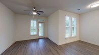 This 1-bedroom, 1-bathroom residence offers a thoughtfully designed single-floor layout that maximizes functionality and comfort. The open-concept living and dining area is finished with rich hardwood-style flooring and features multiple windows dressed with horizontal blinds, allowing abundant natural light to fill the space. A ceiling fan adds both style and practicality to the living area, which also includes a private exterior door — ideal for outdoor access.

The kitchen is a standout feature, showcasing dark espresso cabinetry, granite countertops, a peninsula with a built-in sink, and a full suite of stainless steel appliances including a refrigerator, electric range, and microwave. Pendant lighting above the peninsula adds a modern touch, and the open sightlines keep the kitchen connected to the main living area.

The bedroom is carpeted for warmth and comfort, complete with a ceiling fan and access to a well-sized closet. The full bathroom features light wood-look flooring, a dark vanity with a granite countertop, a large mirror, and a tub/shower combination.

A dedicated in-unit laundry area with a top-load washer and overhead shelving adds everyday convenience to this efficiently laid-out residence.