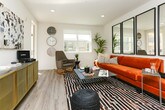 Located in Mountain View, CA, this single-floor residence showcases a contemporary design defined by clean lines, light wood-style flooring, and a neutral white palette throughout. The open-concept kitchen is a standout feature, equipped with dark flat-front cabinetry, light quartz countertops, stainless steel appliances including a French door refrigerator, electric range, and built-in microwave. A spacious peninsula with an undermount sink and bar seating for multiple guests creates a seamless transition into the living and dining areas. Recessed lighting illuminates the space efficiently throughout.

The living area benefits from multiple windows that invite natural light and offer views of the surrounding neighborhood. The layout is well-proportioned, providing ample room for varied furniture arrangements. The bedroom continues the consistent aesthetic with wood-style flooring, a window framing outdoor views, and flexible lighting options.

The bathroom features dark vanity cabinetry paired with a white quartz countertop, a large mirror, and a combined shower and bathtub. Light wood-style flooring ties the bathroom seamlessly to the rest of the unit's cohesive, modern design.
